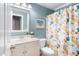 Bathroom featuring a white vanity, bright blue walls, and a colorful shower curtain at 429 Marsh Landing Dr, Holly Springs, NC 27540