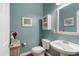 Charming half bathroom featuring a pedestal sink, toilet, and decorative accents on a teal wall at 429 Marsh Landing Dr, Holly Springs, NC 27540