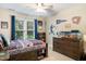 A cozy bedroom with baseball decor, window, ceiling fan and a dresser at 429 Marsh Landing Dr, Holly Springs, NC 27540