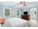 Bright bedroom with two windows, ceiling fan, and a dark wood dresser at 429 Marsh Landing Dr, Holly Springs, NC 27540