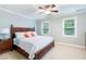 Cozy bedroom with a dark wood bed frame, two windows, and light blue walls at 429 Marsh Landing Dr, Holly Springs, NC 27540