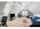 Spacious bonus room with vaulted ceilings and a cozy seating area with a blue sofa at 429 Marsh Landing Dr, Holly Springs, NC 27540