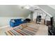 Comfortable bonus room with a blue sofa, a work space, and a colorful striped rug at 429 Marsh Landing Dr, Holly Springs, NC 27540