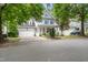 Two-story home with a two car garage, blue shutters, front porch, and driveway on a tree lined street at 429 Marsh Landing Dr, Holly Springs, NC 27540