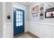 Bright foyer boasts elegant wainscoting, a vibrant blue door, and stylish decor creating a welcoming entrance at 429 Marsh Landing Dr, Holly Springs, NC 27540