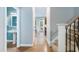 Inviting hallway with wood flooring, a staircase, and a view into the half-bathroom and rear patio at 429 Marsh Landing Dr, Holly Springs, NC 27540