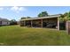 Large, covered metal storage building in a spacious backyard with a wood fence and well-maintained lawn at 45 Hawley Ridge Dr, Dunn, NC 28334