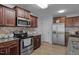 Modern kitchen featuring stainless steel appliances, granite countertops, and wood cabinetry with convenient access to the dining area at 45 Hawley Ridge Dr, Dunn, NC 28334