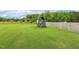 Lush backyard featuring a charming playhouse, surrounded by a well-maintained green lawn and wooden fence at 4504 Beckel Rd, Willow Springs, NC 27592