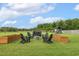 Scenic backyard featuring a cozy fire pit area with Adirondack chairs and lush green lawn at 4504 Beckel Rd, Willow Springs, NC 27592