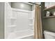 A clean and functional bathroom features a shower-tub combination, toilet, and shelving for practical storage solutions at 4504 Beckel Rd, Willow Springs, NC 27592