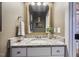 Bathroom vanity with granite countertop, wooden-framed mirror, and decorative accents at 4504 Beckel Rd, Willow Springs, NC 27592