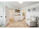 Bright bedroom showcases a cozy armchair, with views into other rooms; featuring a mix of open doorways and neutral tones at 4504 Beckel Rd, Willow Springs, NC 27592