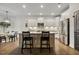 Well-lit kitchen featuring white cabinets, stainless appliances, granite counters, and an island with bar stools at 4504 Beckel Rd, Willow Springs, NC 27592