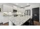 Spacious kitchen with white cabinetry, stainless steel appliances, and granite island with bar seating at 4504 Beckel Rd, Willow Springs, NC 27592