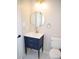 Stylish bathroom with navy blue vanity, gold fixtures, and a round framed mirror at 5013 Brassfield Dr, Rocky Mount, NC 27803