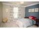 Charming bedroom with a blue accent wall, decorative dog art, and soft neutral colors at 5013 Brassfield Dr, Rocky Mount, NC 27803