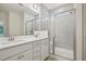 Bathroom features a double sink vanity, grey tile, and glass-enclosed shower with seating at 529 Winding Creek Drive Dr, Lillington, NC 27546