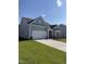 Light blue single-story home with attached two-car garage and green lawn and garden at 529 Winding Creek Drive Dr, Lillington, NC 27546