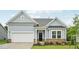 Charming home featuring light blue siding, a brick foundation, and an attached two-car garage at 529 Winding Creek Drive Dr, Lillington, NC 27546