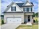 Charming two-story home featuring a two-car garage and a classic black-and-white color scheme at 58 Butterbean Ct, Zebulon, NC 27597