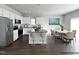 Spacious kitchen with an island, stainless appliances, and a dining area with a marble table at 58 Butterbean Ct, Zebulon, NC 27597