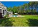 Backyard view featuring pool, manicured lawn, and lush tree line at 6 Castlewood Dr, Durham, NC 27713