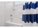 Clean white bathroom with shower-tub combo and a blue and white striped shower curtain at 6 Castlewood Dr, Durham, NC 27713