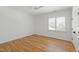 Bright bedroom features hardwood floors, a window with shutters, and neutral walls at 6 Castlewood Dr, Durham, NC 27713
