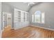 Vaulted bedroom with custom built-in bookshelves, window, and hardwood floors at 6 Castlewood Dr, Durham, NC 27713