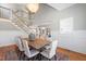 Open-concept dining room showcases a rustic table, chandelier, and staircase access to the upper level at 6 Castlewood Dr, Durham, NC 27713