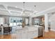 Kitchen island complete with farmhouse sink, white cabinetry, and stainless steel dishwasher at 6 Castlewood Dr, Durham, NC 27713