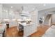Modern kitchen features white cabinets, a center island, stainless appliances, and opens to staircase at 6 Castlewood Dr, Durham, NC 27713