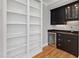 Living room showcasing custom built-ins, a wet bar with wine cooler, and hardwood floors at 6 Castlewood Dr, Durham, NC 27713