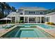Backyard pool and spa with stone border with rear exterior of the house at 6 Castlewood Dr, Durham, NC 27713