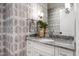 Elegant powder room with patterned wallpaper, decorative mirror, marble vanity, and chrome hardware at 6 Castlewood Dr, Durham, NC 27713