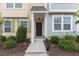 Inviting front entrance featuring a well-lit porch, manicured bushes and a neatly maintained walkway at 608 Grand Central Sta, Apex, NC 27502