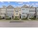 Daytime street view showcases well-maintained townhouses with uniform landscaping and dedicated parking spaces at 608 Grand Central Sta, Apex, NC 27502