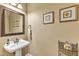Elegant half bathroom with pedestal sink, decorative mirror, and tasteful wall decor at 625 Canvas Dr, Wake Forest, NC 27587