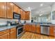 Modern kitchen featuring stainless steel appliances, granite countertops, and wooden cabinets at 625 Canvas Dr, Wake Forest, NC 27587