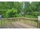 Wooden back deck with wooden railing overlooks private backyard with lush trees at 6904 Fox Haven Pl, Raleigh, NC 27616