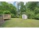 Spacious backyard with a deck, shed, and lush green grass at 6904 Fox Haven Pl, Raleigh, NC 27616