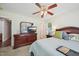 Cozy bedroom with a ceiling fan, dresser with TV, and comfortable bed with blue bedding at 6904 Fox Haven Pl, Raleigh, NC 27616