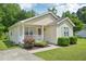 Charming one-story home with light-yellow siding, blue shutters, a cozy porch, and lovely landscaping at 6904 Fox Haven Pl, Raleigh, NC 27616
