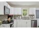Bright kitchen featuring white cabinets, stainless steel appliances, and granite countertops at 6904 Fox Haven Pl, Raleigh, NC 27616