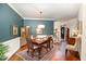 Formal dining room with wainscotting, wood floors, and a view into the entryway and staircase at 8005 Crookneck Dr, Angier, NC 27501
