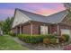 Charming brick home featuring manicured landscaping, green lawn, black shutters, and a delightful water fountain at 8005 Crookneck Dr, Angier, NC 27501