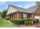 Charming brick home featuring manicured landscaping, green lawn, black shutters, and a delightful water fountain at 8005 Crookneck Dr, Angier, NC 27501