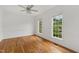 Bright bedroom features hardwood floors, two large windows, and modern ceiling fan at 809 Parkridge Dr, Clayton, NC 27527