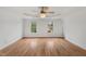 Large bedroom with hardwood floors, decorative ceiling fan, and natural light streaming in from windows at 809 Parkridge Dr, Clayton, NC 27527